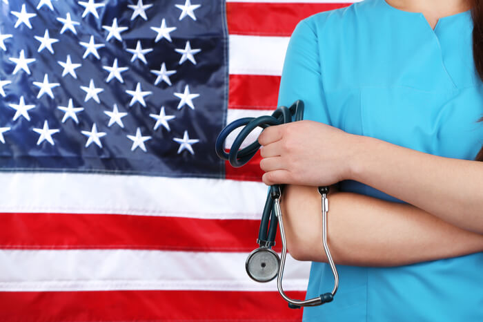 Ärztin vor USA-Flagge