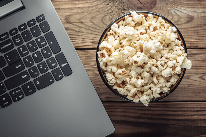 Streaming mit Freunden: Popcorn-Schüssel neben einem Laptop