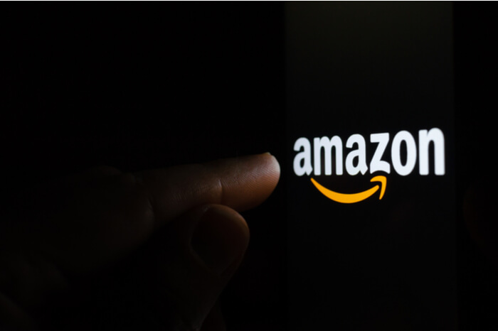 Finger tippt auf ein Amazon-Logo auf einem Bildschirm