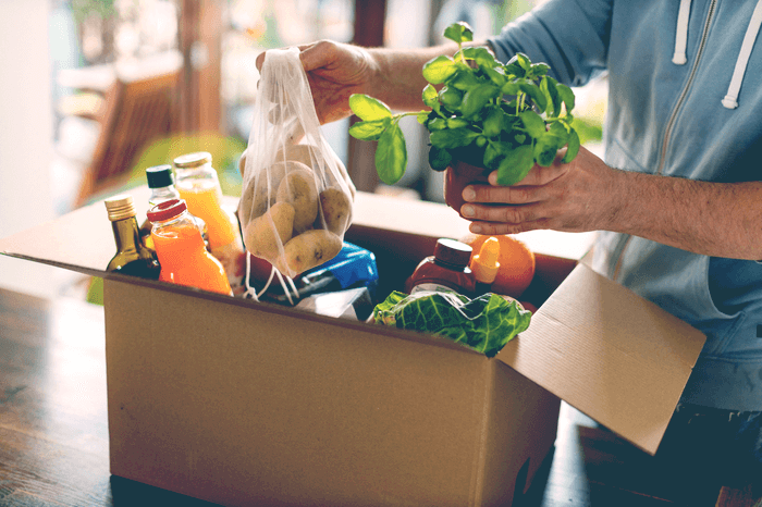 Essen in einem Karton: Mann mit Lebensmittel-Lieferung