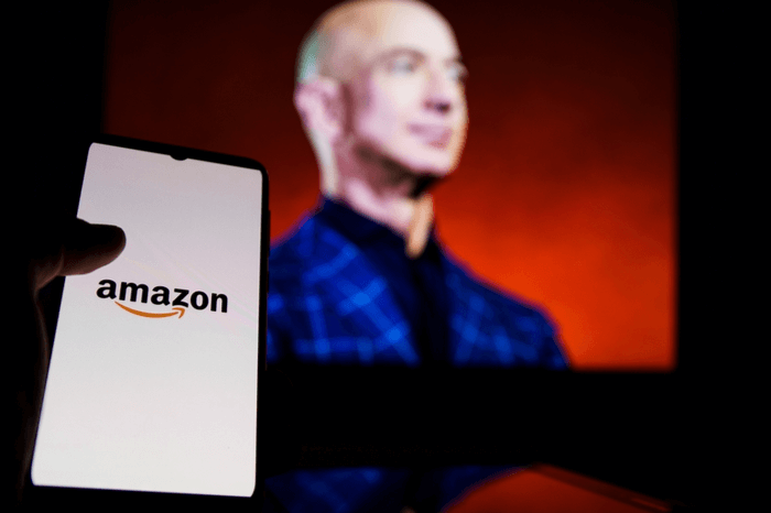 Smartphone mit Amazon-Logo, dahinter Amazon-Gründer Jeff Bezos