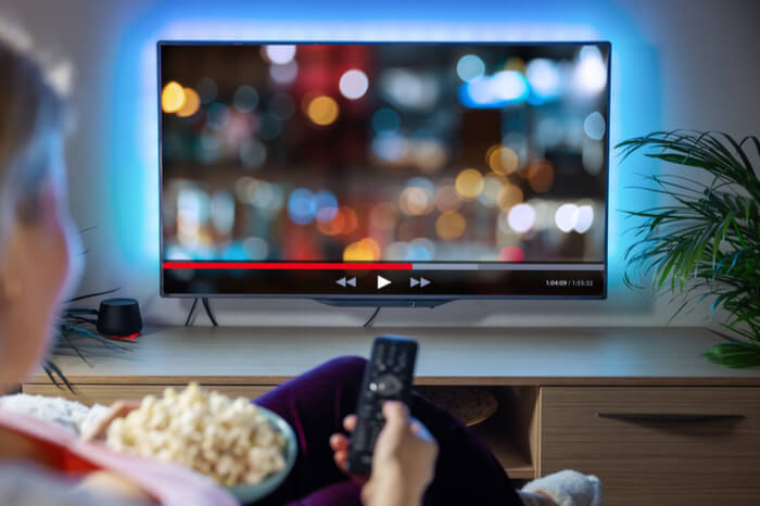 Frau streamt Filme und Serien auf TV-Gerät