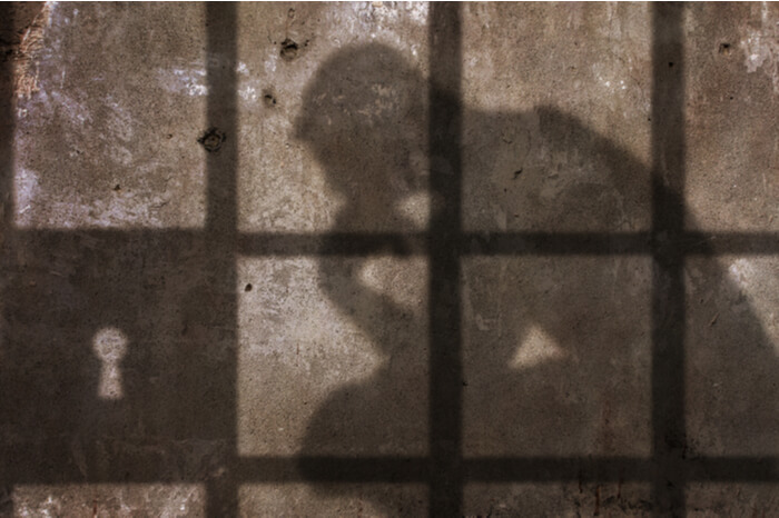 Schatten von Mann hinter Gitter