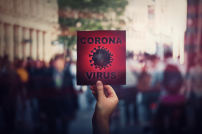 Corona-Schild in den Händen eines Menschen