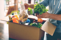 Essen in einem Karton: Mann mit Lebensmittel-Lieferung