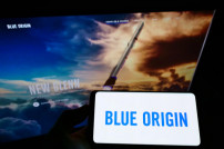 Rakete vor dem Unternehmensschriftzug von Blue Origin