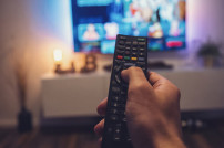 Amazon Watch-Party: Männliche Hand, die TV-Fernbedienung hält
