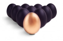 Ein goldenes Ei, umgeben von schwarzen Eiern
